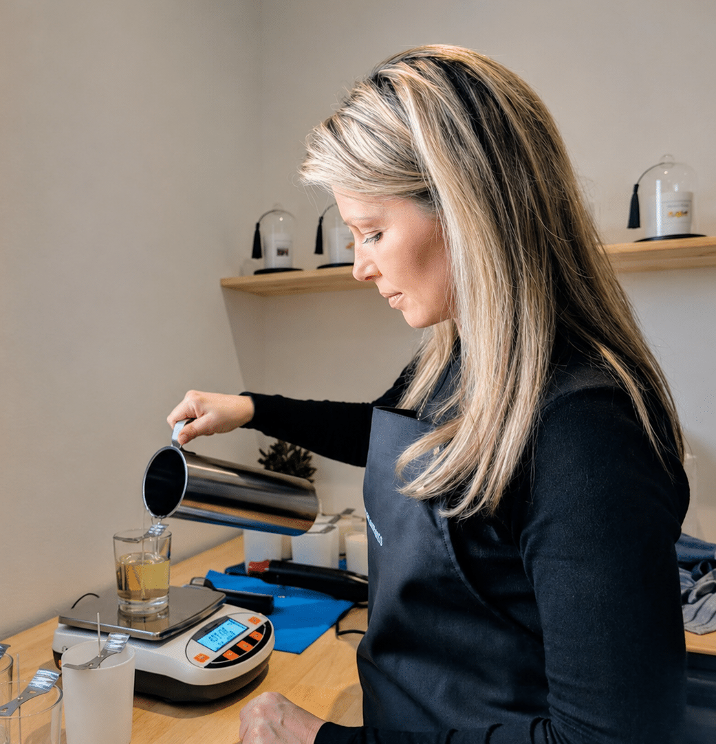 Artisan Lueurs & Fragrances versant la cire dans son atelier